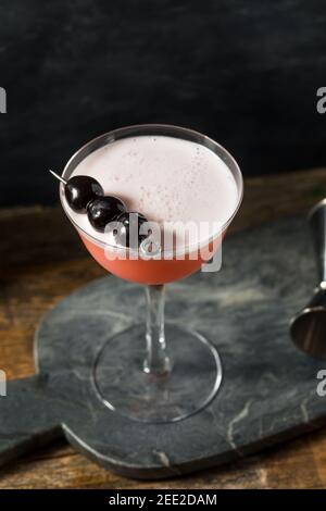 Rinfrescante cocktail rosa con gin e ciliegie Foto Stock