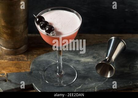 Rinfrescante cocktail rosa con gin e ciliegie Foto Stock