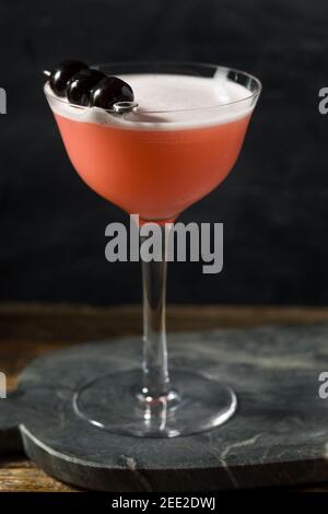 Rinfrescante cocktail rosa con gin e ciliegie Foto Stock