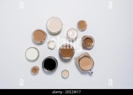 Un colpo concettuale con latte/tè/caffè in tazze disposte in modo da creare un effetto gradiente di colori. Sfumature di caffè. Foto Stock