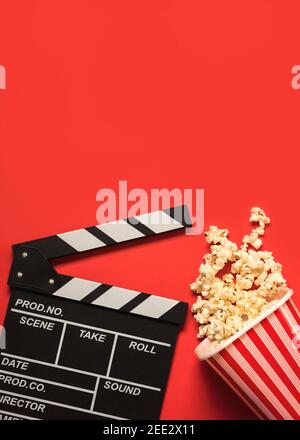 clapperboard filmato con popcorn e spazio per il testo su a. Sfondo rosso.Cinema Concept background Foto Stock