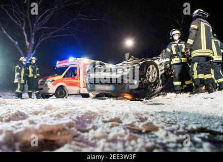 Oststeinbek, Germania. 15 Feb 2021. Un'auto si trova sul tetto della strada di campagna tra Oststeinbek e Havighorst dopo un incidente stradale. Il conducente aveva guidato la sua auto fuori strada sulla strada sdrucciolevole e nevosa, ha colpito un albero e poi ha ribaltato sul tetto. L'uomo è stato ferito nel processo. Credit: Daniel Bockwoldt/dpa - ATTENZIONE: La targa è stata pixelata per motivi legali/dpa/Alamy Live News Foto Stock