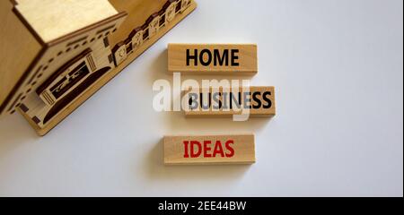 Simbolo delle idee di affari domestici. Blocchi di legno formano le parole 'idee di affari domestici 'vicino casa in miniatura su sfondo bianco bello. Affari, busi domestico Foto Stock