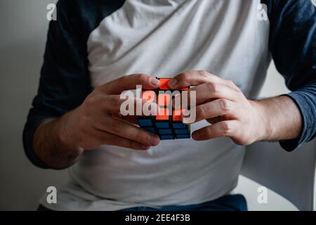 uomo molto intelligente risolvere un cubo di rubik, livello di iq molto alto, giovane molto intelligente Foto Stock