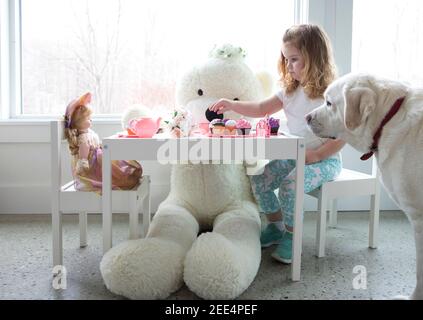 Una bambina che ha un pretend tè partito. Foto Stock