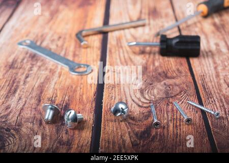 Viti di varie misure su fondo di legno scuro Foto Stock