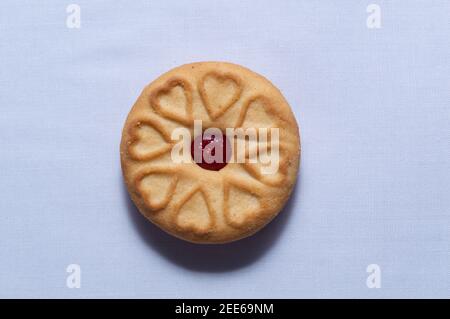 Biscotti rossi con confettura centrata con un sapore di fragola su un sfondo bianco chiaro Foto Stock