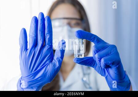 vaccino nelle mani dei ricercatori, il medico femminile tiene siringa e flacone con vaccino per la cura del coronavirus. Concetto di trattamento del virus corona, iniezione, s Foto Stock