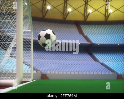 Palla di calcio che entra nel gol all'interno di uno stadio sportivo con la tribuna sullo sfondo. Foto Stock