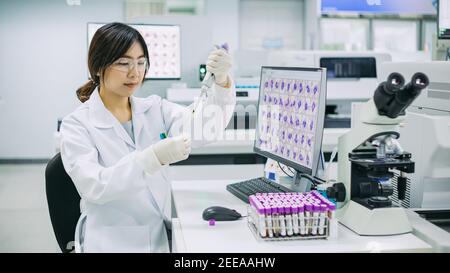 Tecnico medico che si sta pipettando con provette per analisi di campioni di sangue in laboratorio. Concetto di chimica microbiologica HIV ematologia scienziato. Foto Stock