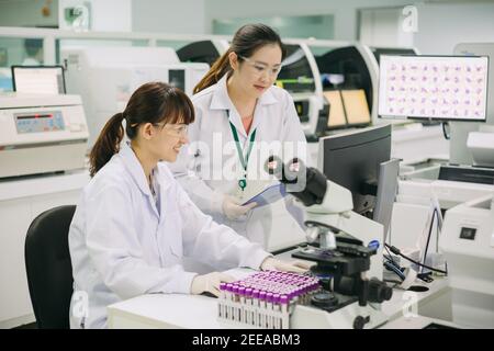 Medico che lavora per analizzare campioni di sangue in laboratorio di ricerca scientifica. Concetto di chimica biologica ematologia HIV. Foto Stock