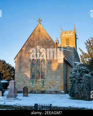 Chiesa di San Pietro e San Paolo nella neve di gennaio appena dopo l'alba. Long Compton, Warwickshire, Inghilterra Foto Stock