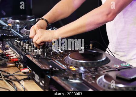 DJ che riproduce musica sul controller mixer digitale. Messa a fuoco selettiva. Foto Stock