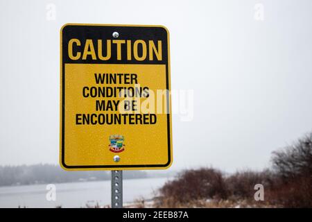 Courtenay, Canada - 24 gennaio 2021: Vista del segno le condizioni invernali possono essere incontrate con la neve sullo sfondo. Percorso lungo il fiume Courtenay. Foto Stock