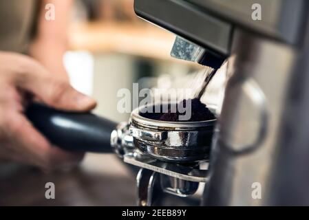 Macinacaffè automatico per macinare i chicchi di caffè nel cestello portafiltro Foto Stock