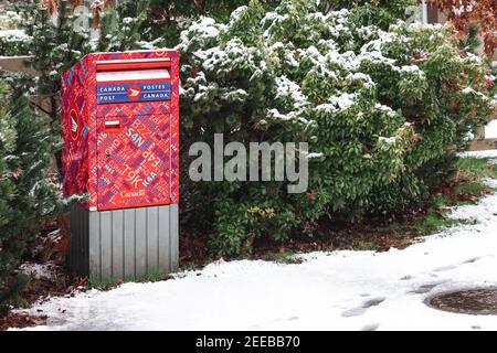 Courtenay, Canada - 24 gennaio 2021: Una scatola della lettera della via del Canada posta sta sulla strada durante una nevicata invernale Foto Stock