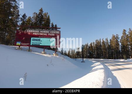 Cartello d'ingresso per Canmore, Alberta Nordic Center Provincial Park con informazioni sulla distanza fisica Foto Stock