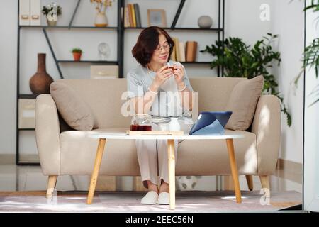 Donna anziana che guarda il film online Foto Stock