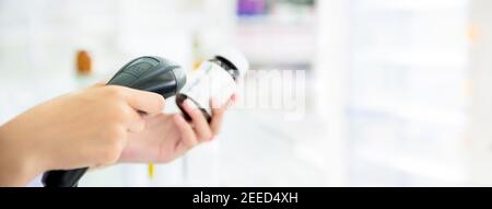 Flacone di medicina a scansione con lettore di codici a barre in farmacia - banner panoramico con spazio per la copia a destra Foto Stock