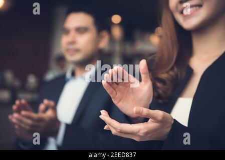 Donna d'affari e uomo d'affari applaudendo un accordo durante una riunione di affari in caffetteria Foto Stock