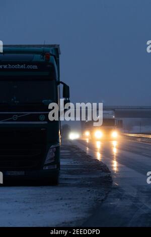 Breitenau, Germania. 16 Feb 2021. Un autocarro è parcheggiato sulla spalla dura, mentre diversi autocarri con veicoli nuovi caricati entrano in Germania dalla direzione della Repubblica Ceca sulla A17 vicino a Breitenau. Dal 14.02.2021, controlli più severi da parte della polizia federale ai confini con la Sassonia stanno cercando di fermare le mutazioni del coronavirus. Credit: Daniel Schäfer/dpa-Zentralbild/dpa/Alamy Live News Foto Stock