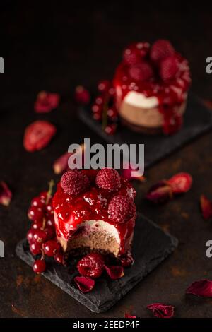 Torta europea moderna. Mini torta rotonda di lamponi con cioccolato e frutti di bosco freschi Foto Stock