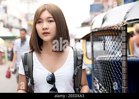 Donna asiatica turista zaino in spalla che cammina in Khao San strada, viaggiando da solo in vacanza a Bangkok - Thailandia Foto Stock