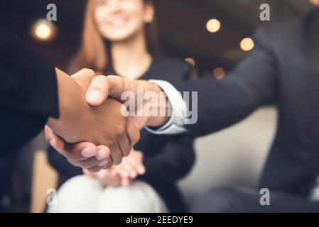 Uomini d'affari che fanno stretta di mano con il suo partner in cafe - business etiquette, congratulazioni, fusione e concetti di acquisizione Foto Stock