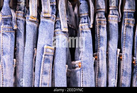 Diverse coppie di jeans blu su appendiabiti, primo piano foto. Riga dimensioni jeans. Cravatta Dye jeans vestiti foto. Indossare tutti i giorni su appendiabiti in negozio. Negozio di moda Bla Foto Stock