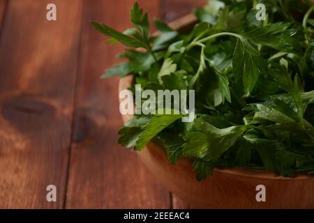 Il prezzemolo mazzo in una ciotola su sfondo di tavola di legno. Prezzemolo fresco su sfondo di legno. Crema di prezzemolo biologico su tavola rustica, cibo vegetariano overhea Foto Stock