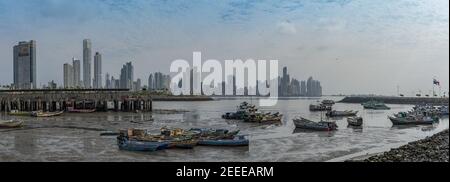 Vecchie barche da pesca vicino al mercato del pesce in Panama city con lo sfondo dello skyline di Foto Stock