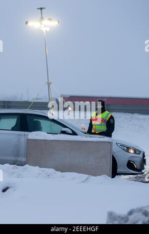 Breitenau, Germania. 16 Feb 2021. Un poliziotto della polizia federale che controlla un pendolari presso il parcheggio di Heidenholz sulla A17 vicino a Breitenau. Le norme tedesche di ingresso al confine con la Repubblica ceca, per proteggere contro le varianti pericolose del coronavirus, sono entrate in vigore nella notte del 14.02.2021. Credit: Daniel Schäfer/dpa-Zentralbild/dpa/Alamy Live News Foto Stock