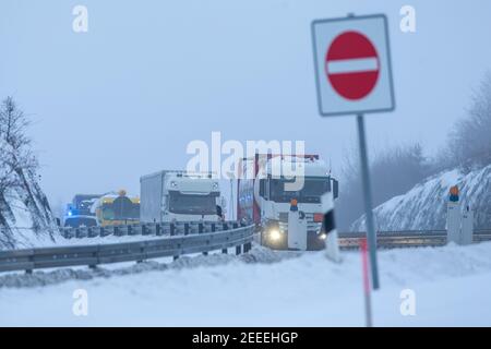 Breitenau, Germania. 16 Feb 2021. Diversi camion si allontanano dal punto di controllo dell'autostrada dopo essere stati controllati dalla polizia federale. La notte del 14.02.2021 sono entrate in vigore le severe norme tedesche di entrata al confine con la Repubblica ceca per proteggere contro le varianti pericolose del coronavirus. Credit: Daniel Schäfer/dpa-Zentralbild/dpa/Alamy Live News Foto Stock