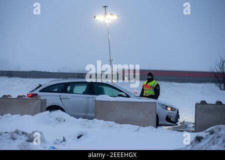 Breitenau, Germania. 16 Feb 2021. Un poliziotto della polizia federale che controlla un pendolari presso il parcheggio di Heidenholz sulla A17 vicino a Breitenau. Le norme tedesche di ingresso al confine con la Repubblica ceca, per proteggere contro le varianti pericolose del coronavirus, sono entrate in vigore nella notte del 14.02.2021. Credit: Daniel Schäfer/dpa-Zentralbild/dpa/Alamy Live News Foto Stock