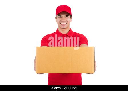 Uomo di consegna sorridente in uniforme rossa dando una scatola, isolato su sfondo bianco - concetto di servizio di corriere Foto Stock