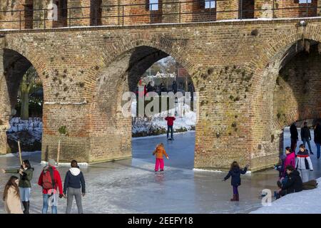 ZUTPHEN, PAESI BASSI - 14 febbraio 2021: Pattinaggio su ghiaccio intorno al portale d'ingresso della città precedente Berkelpoort Foto Stock