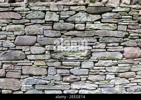 Pareti di pietra asciutte o muri di pietra di fondo e struttura fatta da ardesia naturale a forma regolare a strati o pietra tenuta in posizione senza mortaio può durare hun Foto Stock