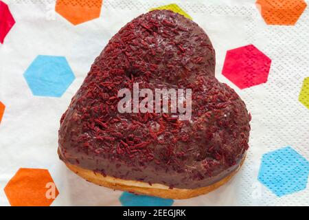 Ciambella a forma di cuore per la giornata di San Valentino dalla panetteria a Marks & Spencer set su tovaglioli serviette Foto Stock