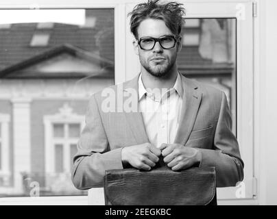 Uomo con valigetta isolata su sfondo bianco. Nerd o brainiac con giacca classica. Sindrome di Bookworm e concetto di lavoro duro. Insegnante o lavoratore serio con setole in calici. Foto Stock