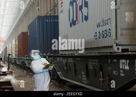 Chengdu/Urumqi. 16 Feb 2021. Un membro del personale controlla i contenitori di un treno merci Cina-Europa al Passo Alataw, nella regione autonoma di Xinjiang Uygur, nella Cina nord-occidentale, 7 febbraio 2021. Credit: Ma Kai/Xinhua/Alamy Live News Foto Stock