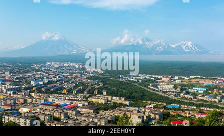 Città Petropavlovsk-Kamchatsky sullo sfondo dei Vulcani Avachinsky, Koryaksky e Kozelsky, Kamchatka Foto Stock