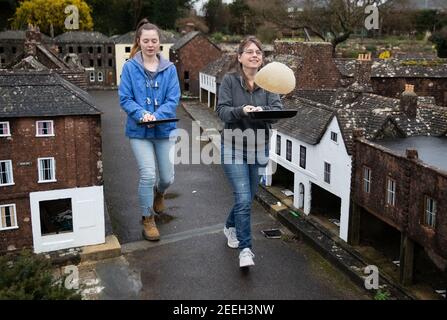 I volontari di madre e figlia Niki (a destra) e Rachel praticano la loro frittella lanciandosi nelle strade della città modello di Wimborne e dei giardini mentre prendono parte alla corsa virtuale delle frittelle di Wimborne Minster. Data immagine: Martedì 16 febbraio 2021. Foto Stock