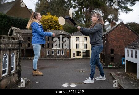 I volontari di madre e figlia Niki (a destra) e Rachel praticano la loro frittella lanciandosi nelle strade della città modello di Wimborne e dei giardini mentre prendono parte alla corsa virtuale delle frittelle di Wimborne Minster. Data immagine: Martedì 16 febbraio 2021. Foto Stock