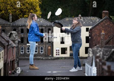 I volontari di madre e figlia Niki (a destra) e Rachel praticano la loro frittella lanciandosi nelle strade della città modello di Wimborne e dei giardini mentre prendono parte alla corsa virtuale delle frittelle di Wimborne Minster. Data immagine: Martedì 16 febbraio 2021. Foto Stock