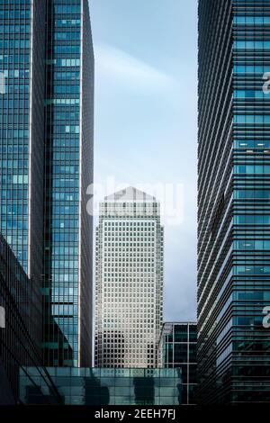 Il quartiere finanziario di Canary Wharf, alto e moderno blocco di uffici in metallo color argento grattacielo a torre circondato da edifici in vetro e blu a lunga esposizione cielo estivo Foto Stock