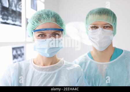 Ritratti di medici chirurghi in abbigliamento protettivo in clinica Foto Stock