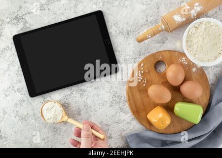 Ingredienti e strumenti per la cottura e la pastiglia con schermo vuoto e posto per il testo o l'immagine su tavola bianca. Ricetta, libro di cucina, corsi di cucina on-line tem Foto Stock