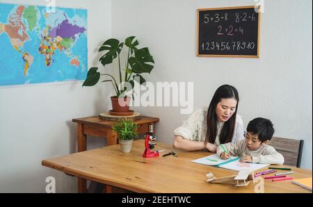 Insegnante asiatico che lavora con bambino ragazzo a prescolare - Focus sulle facce Foto Stock