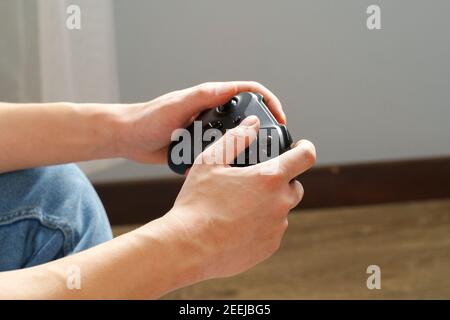 Mani maschili che tengono i video giochi joystick primo piano Foto Stock