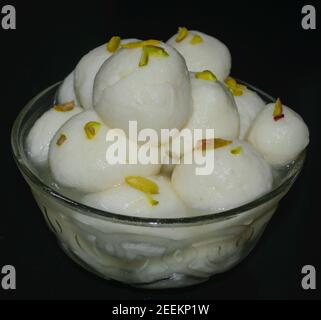 Rasgulla e' una delle famose delicatezze da dessert del Bengalese Indiano, servita con Pistacchio a fette sulla sommita'. Foto Stock